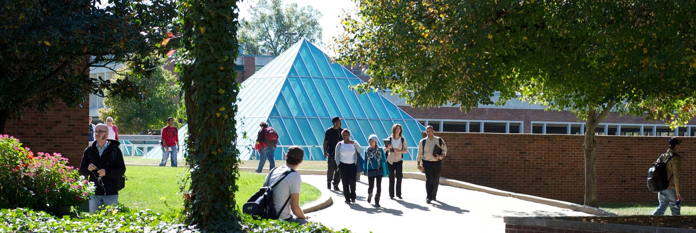 Students walking outside in front of the Mercantile Library's glass pyramid