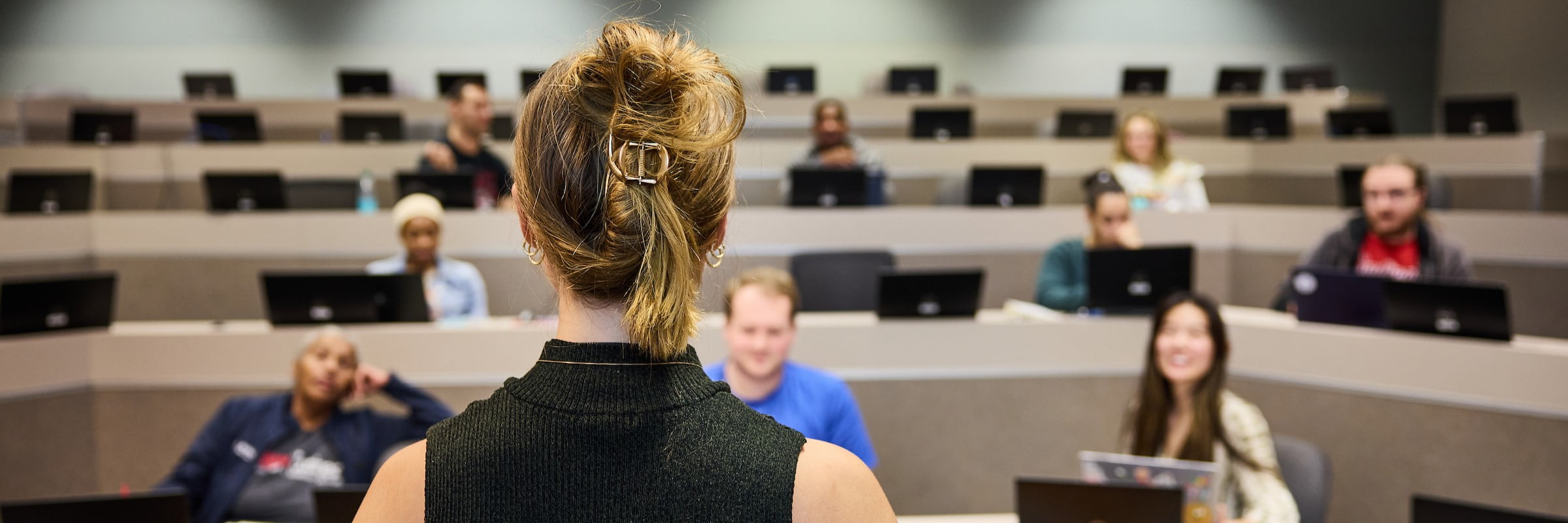 An instructor looks out over an auditorium of students