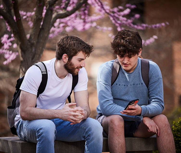 2 male students looking at a phone