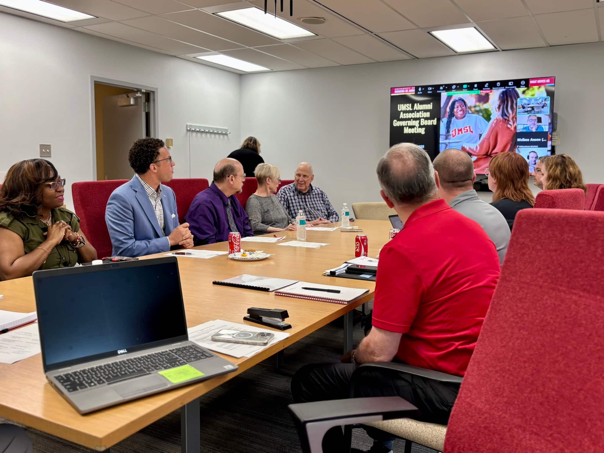 Members of the governing board sit at a conference table for a meeting.
