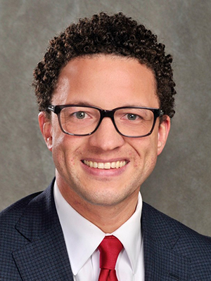 Headshot of Alex Kerford in front of gray backdrop.