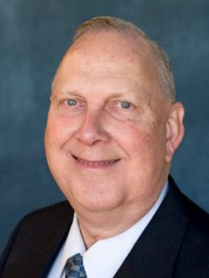 Headshot of Dave Ganz in front of dark backdrop.