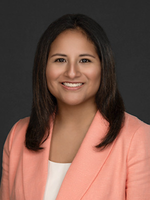 Headshot of Katie Trouton-Alexander in front of a charcoal backdrop.