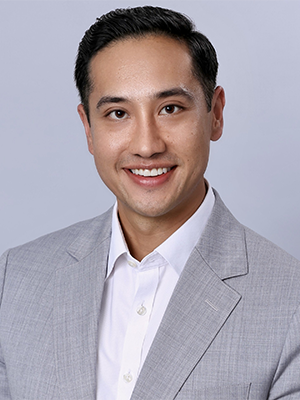 Headshot of Paul Luong in front of a light gray background.