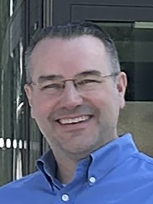 Headshot of Ryan Frisch wearing a blue shirt.
