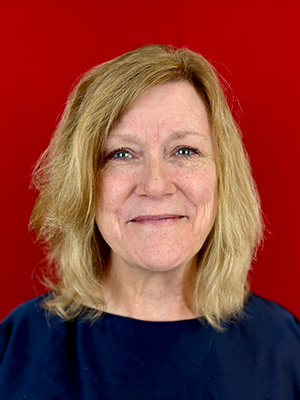 Headshot of Mary Chant in front of red backdrop.