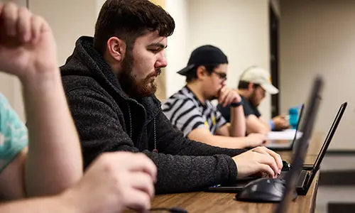 students in class on laptops