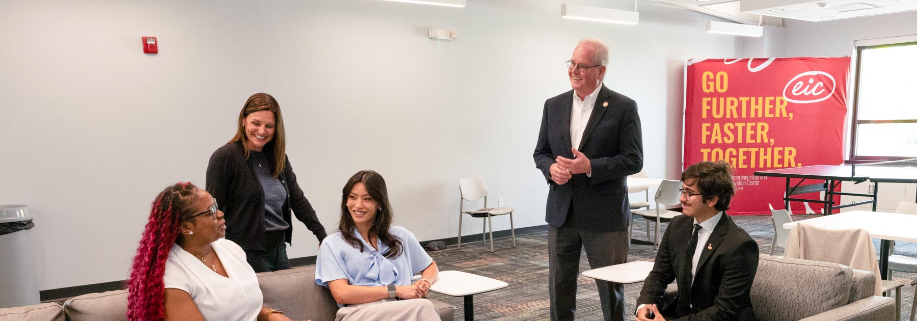 faculty sitting with students smiling