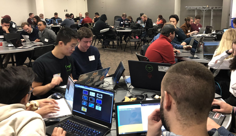 students around a table with laptops