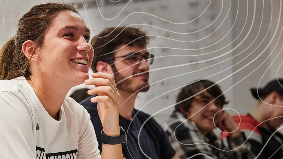two UMSL students and a faculty member examine a plant