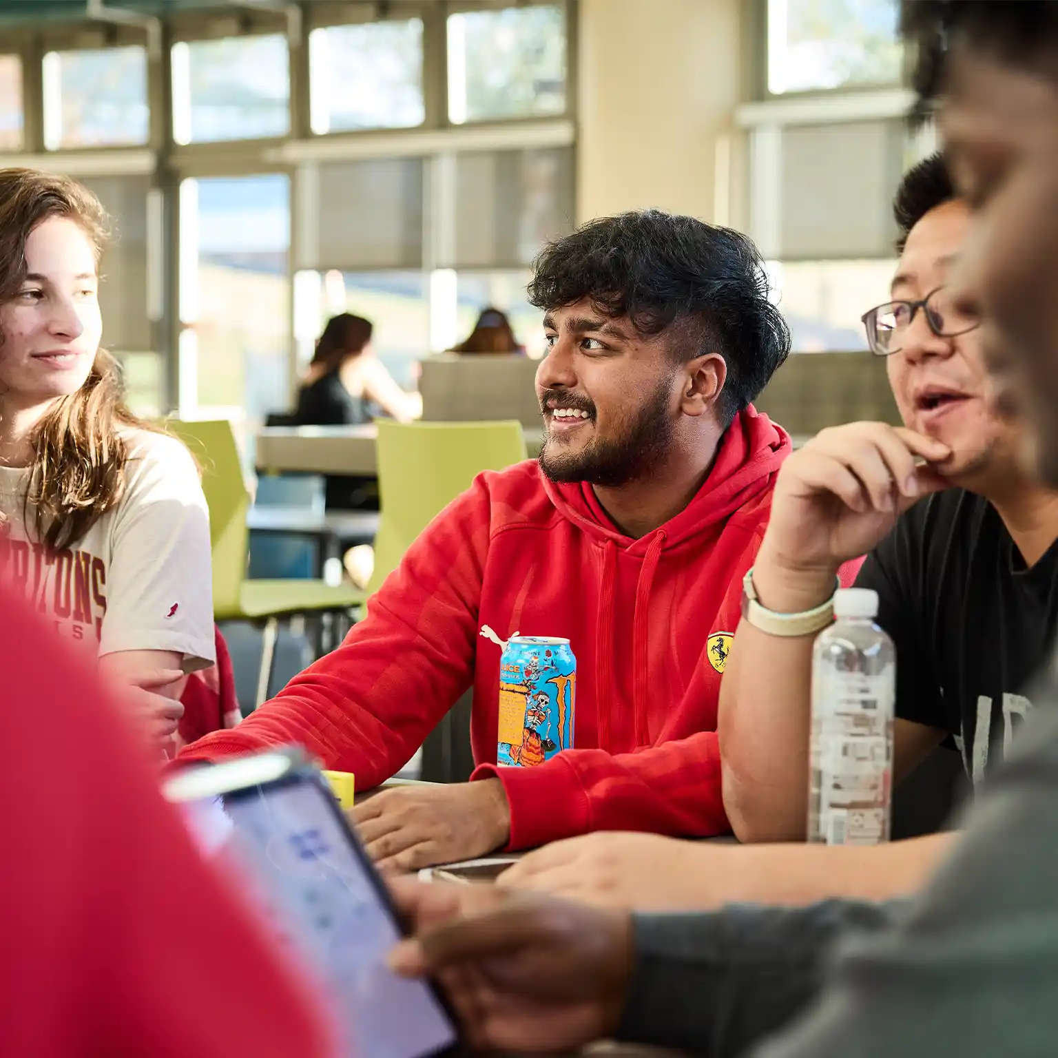 Group of students seated at a table in conversation