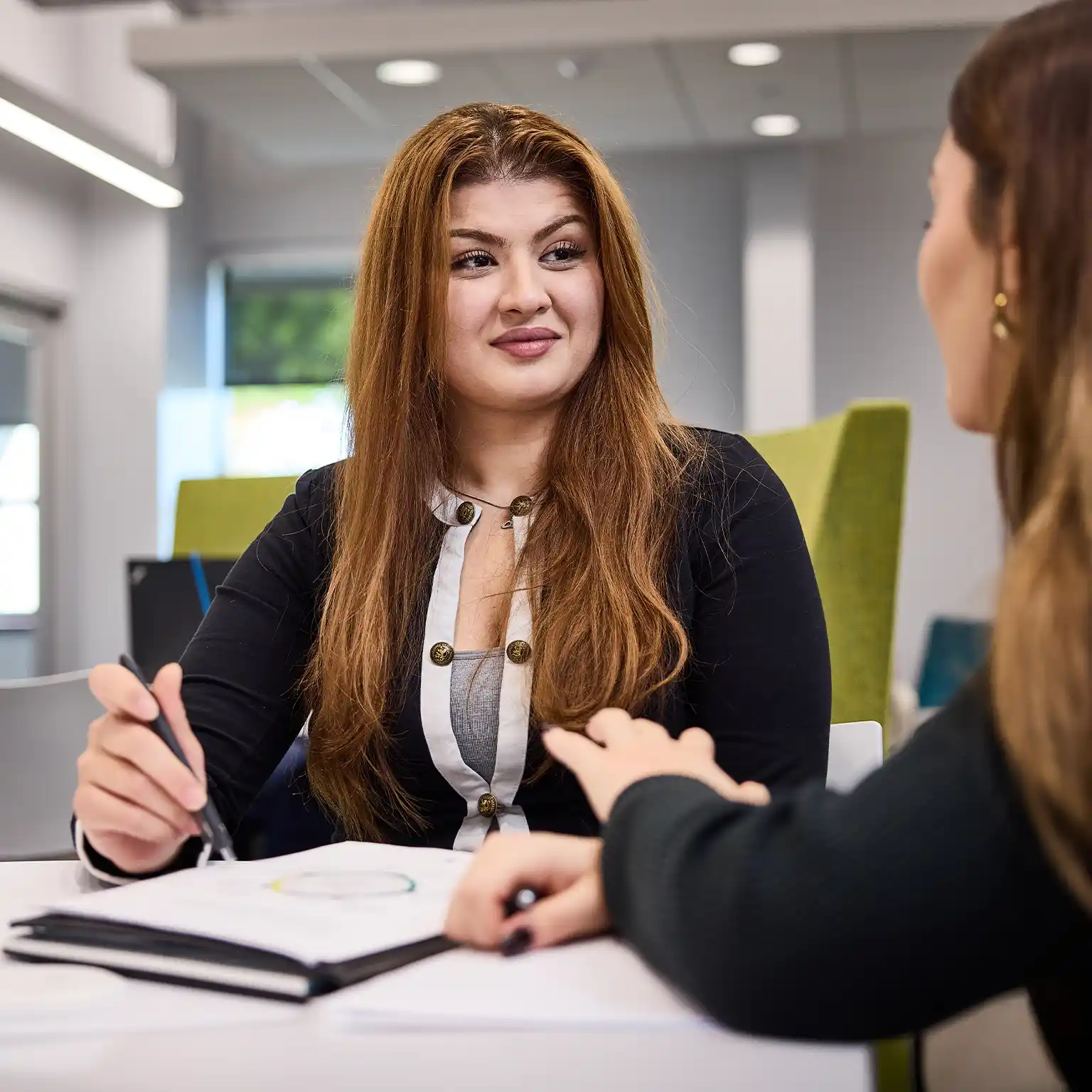 Two students at a table in conversation