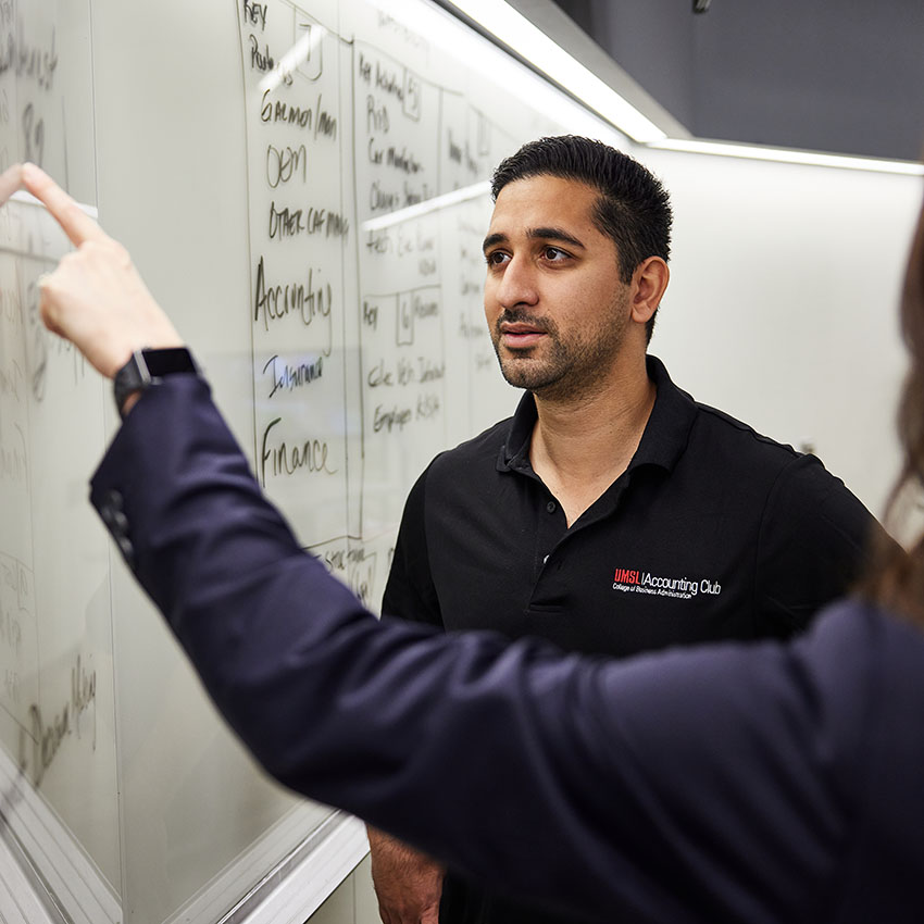 student and professor in front of white board