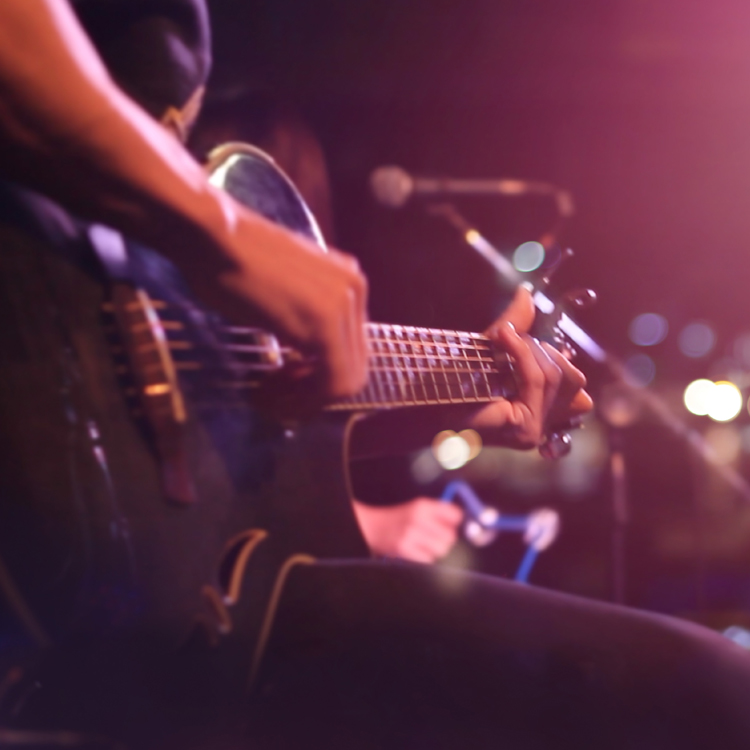 Close-up of a musician playing an acoustic guitar during a live performance.