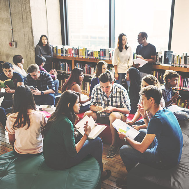 A diverse group of students collaborating and studying together in a modern library setting.