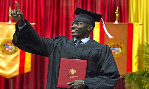 graduate posing with their degree