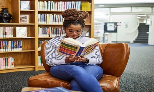 student in the library with a book
