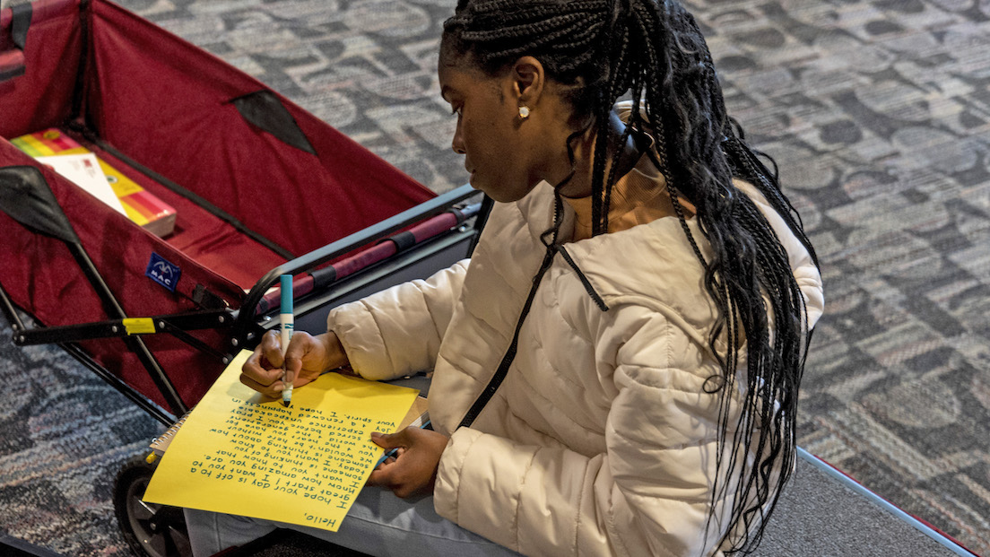 A student writing a loving note to their classmates