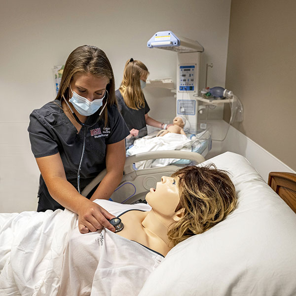 nursing student with adult simulation patient