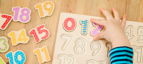 young child playing with number blocks