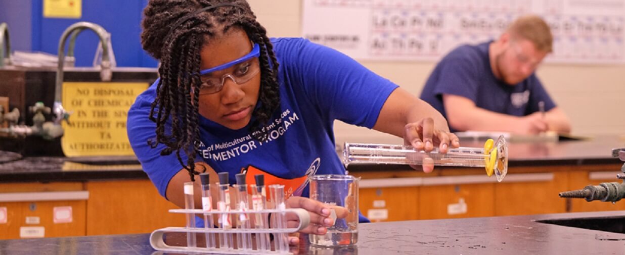 science student pours from glass container