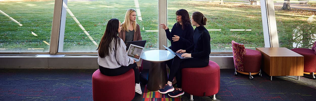 Three students and a professor talking in the Collabitat