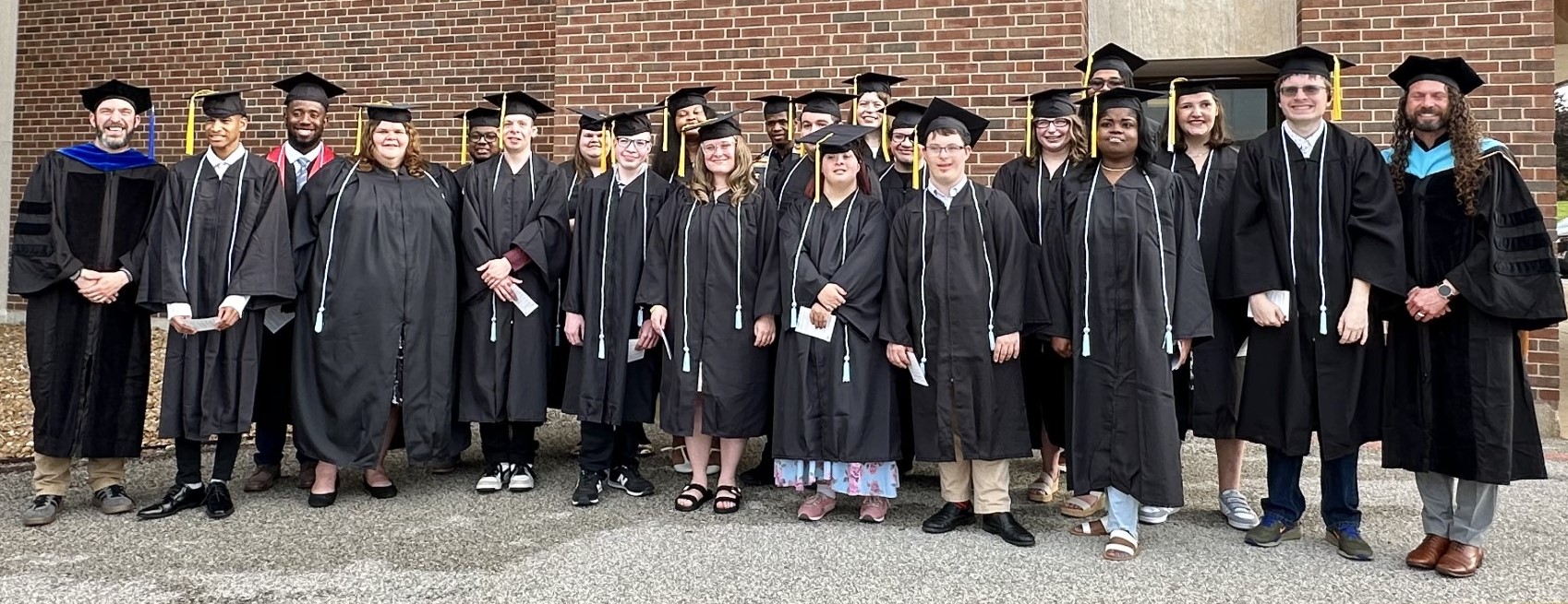 Female and male students in black colored graduation regalia