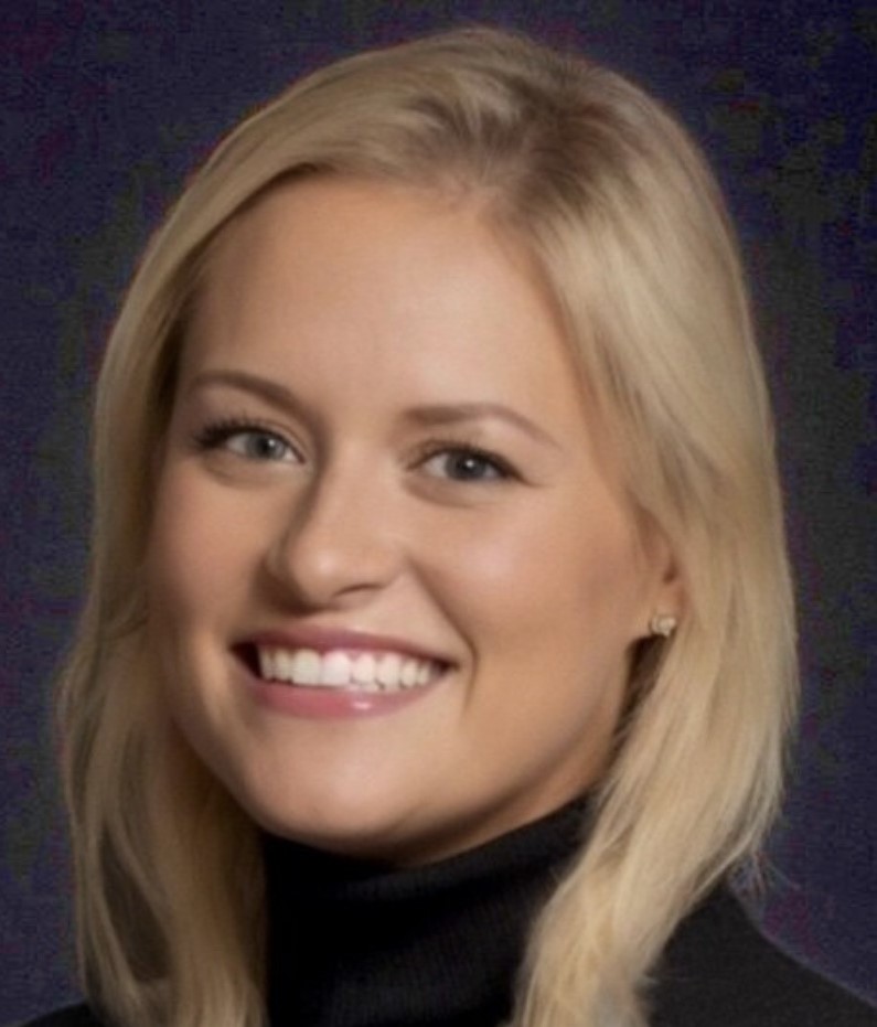 Young woman with shoulder-length blonde hear wearing a black turtleneck top.