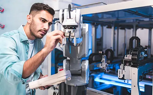 A technician working on a robotic arm in a modern automation environment.