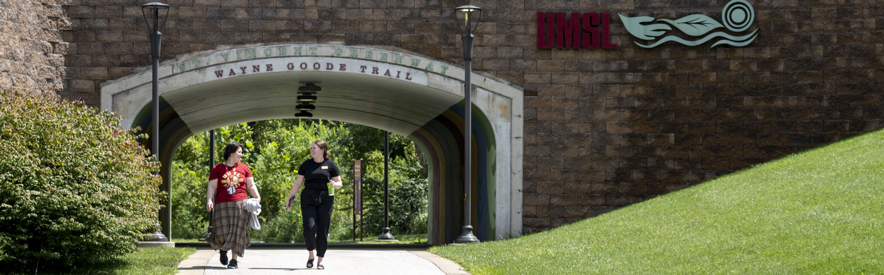 Two staff members walking on the trail on campus