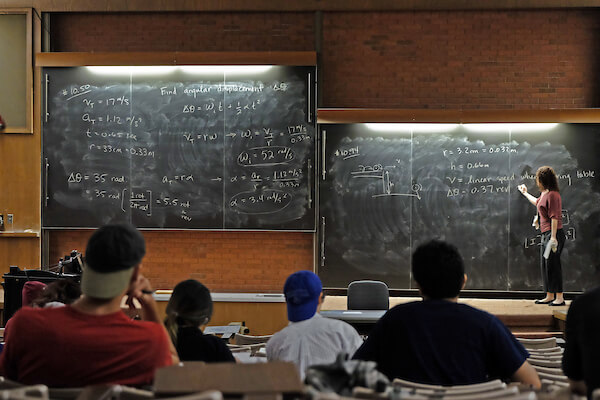 professor by a chalkboard in a classroom