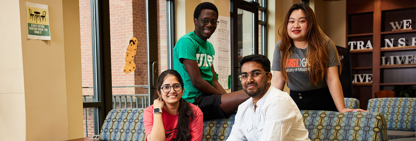 Group of students surrounding a couch