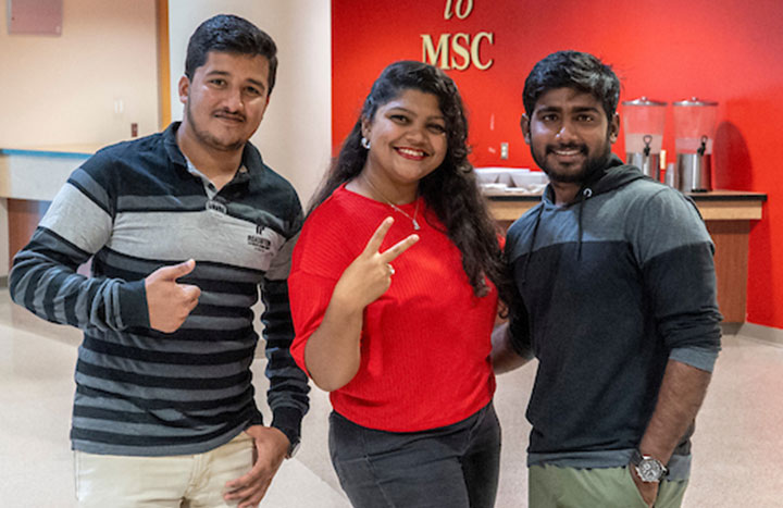 Three students posing for a photo inside the Millennium Student Center