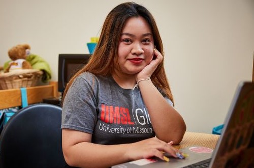 Student at desk with UMSL Global shirt