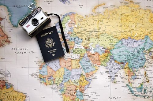 U.S. Passport and camera sitting on top of a world map