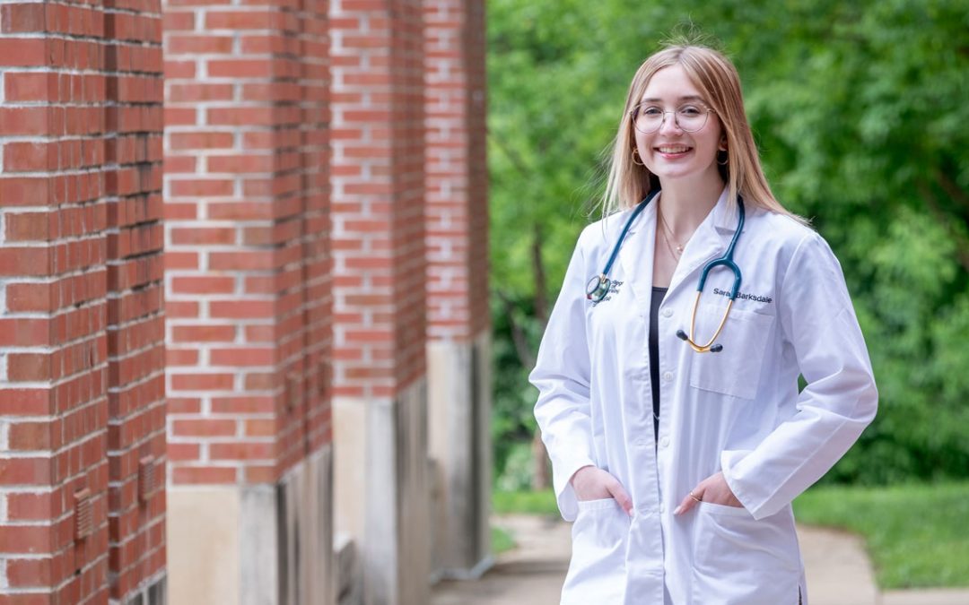 image of a student wearing a white lab coat and stethoscope 