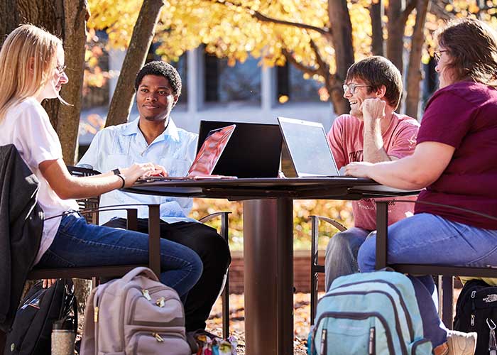 Students outside at round table