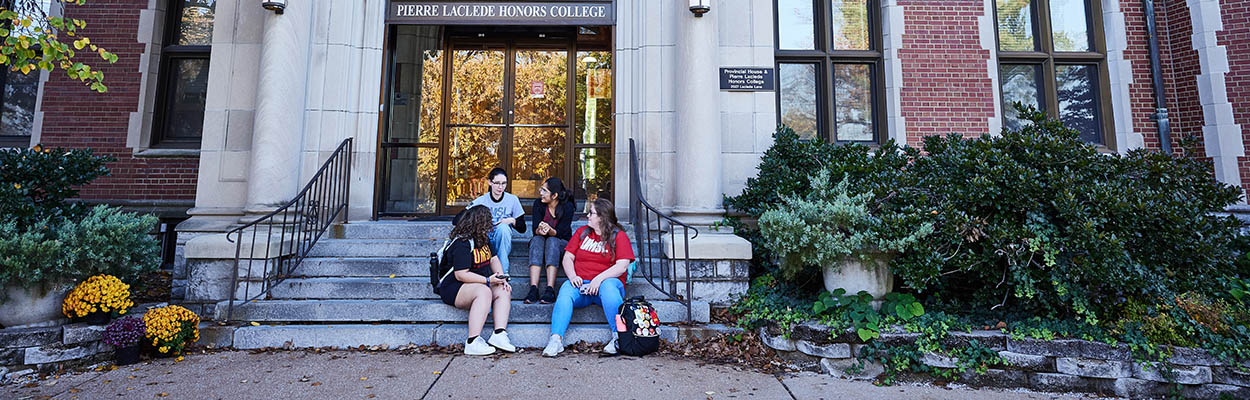 4 students on the steps of the Honors College