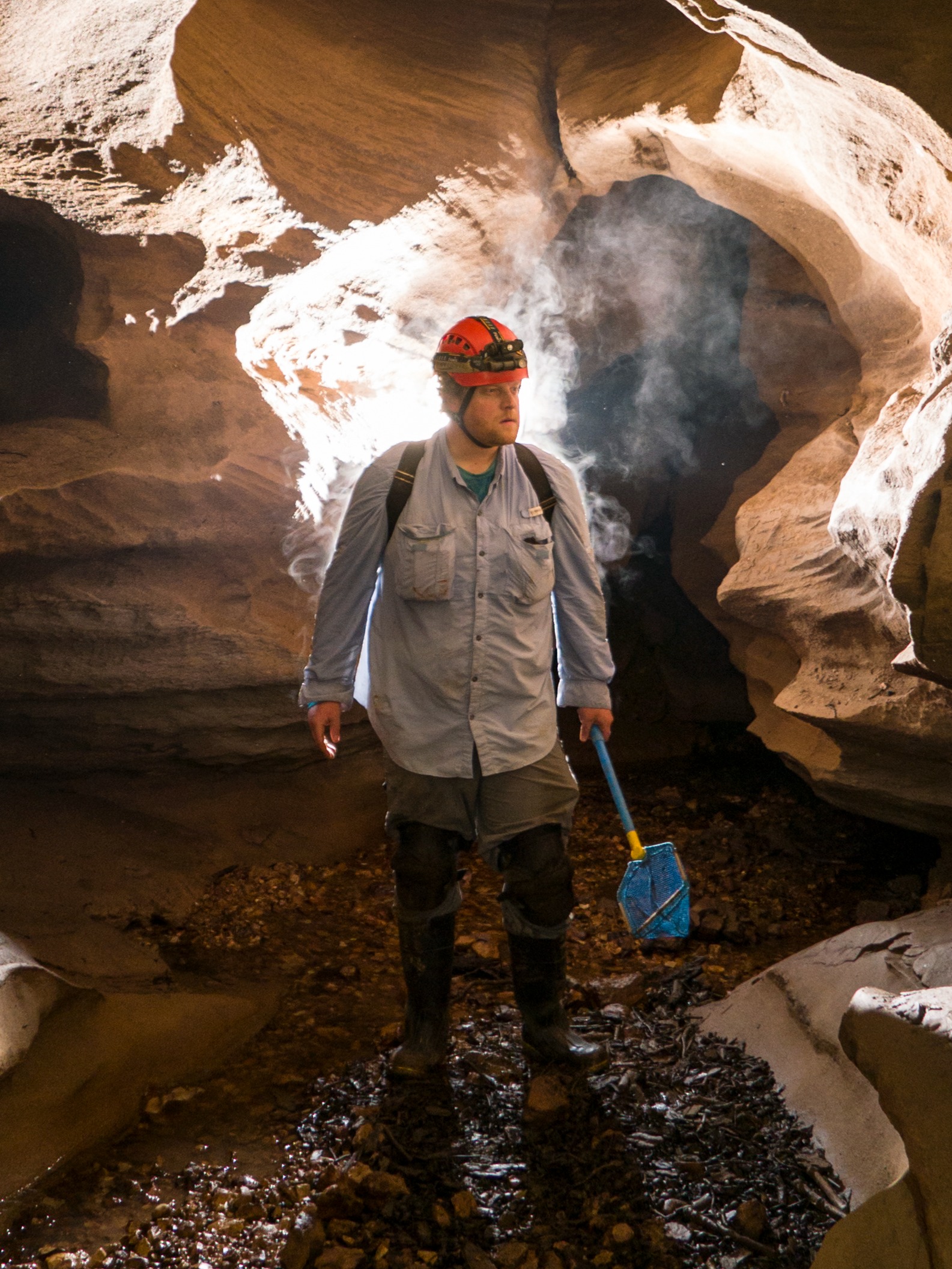 Man stands in cave with shovel