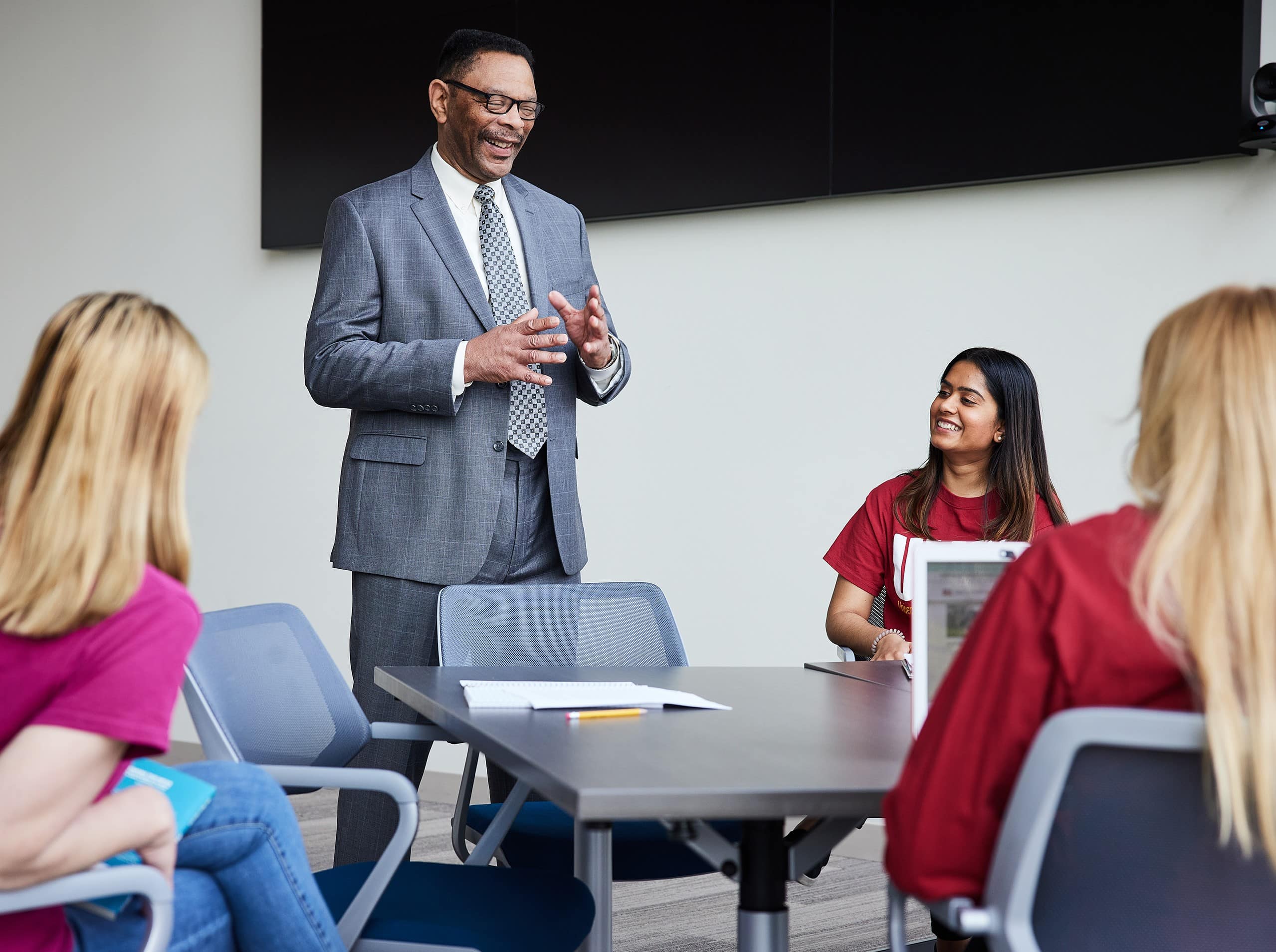 A professor gives a lecture to a table of students