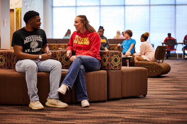 Group of five university students posing together at a campus event.