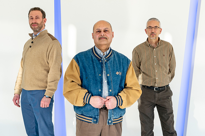 Optometrist Tareq Nabhan (left) and computer scientist Sanjiv Bhatia (center) have been working with research engineering technician Michael Howe to develop a prototype for a device that would allow clinicians to use a smartphone to perform the functions of existing diagnostic tools. (Photo by August Jennewein)