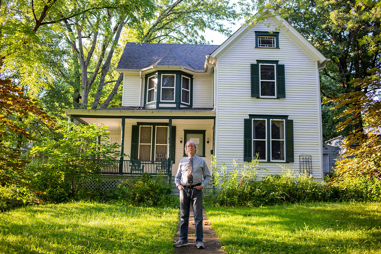 person standing in front of a two story house