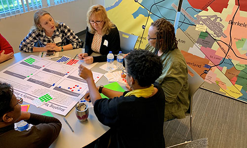 people sitting around a table, map of st louis county in the background