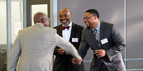 three men, two shaking hands