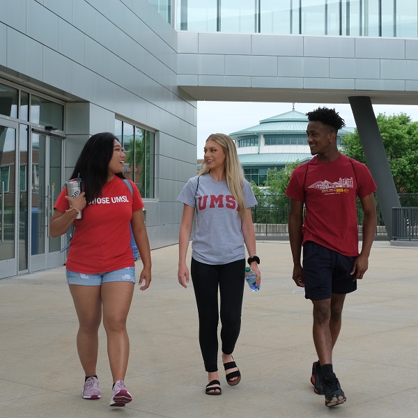 Three students walk outside the Rec Center