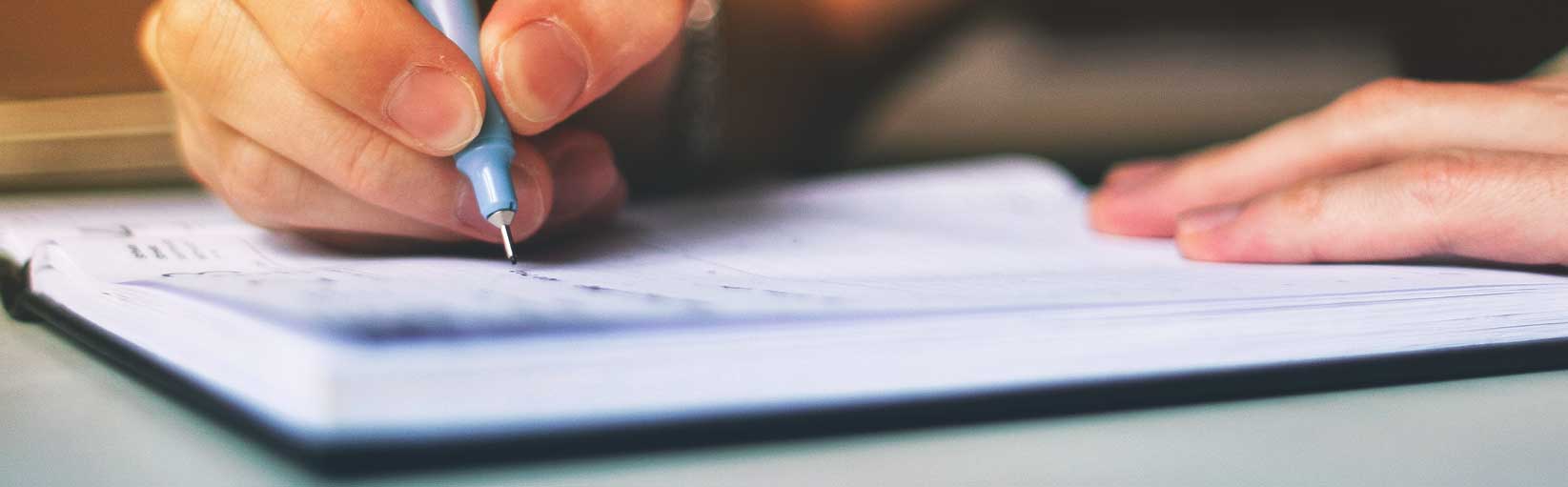 Hands writing in a notebook