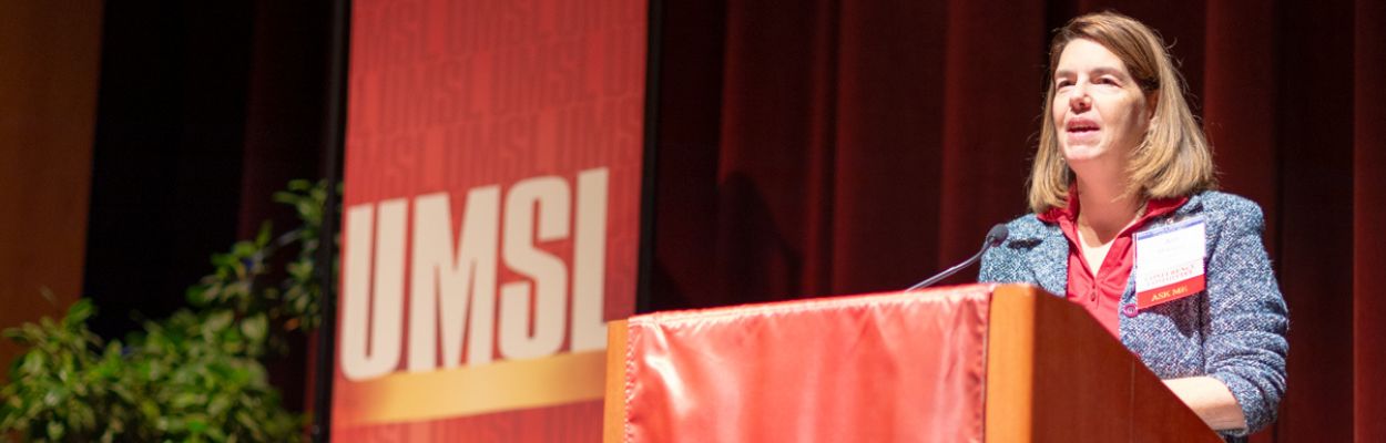 Woman in a business suit standing on a stage 
