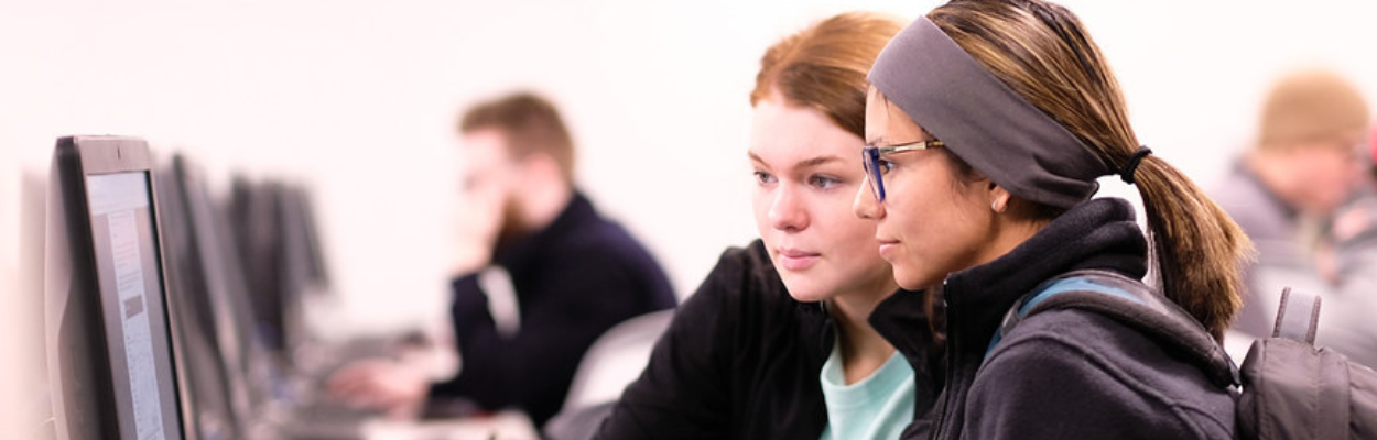 Two students sitting at a computer working together