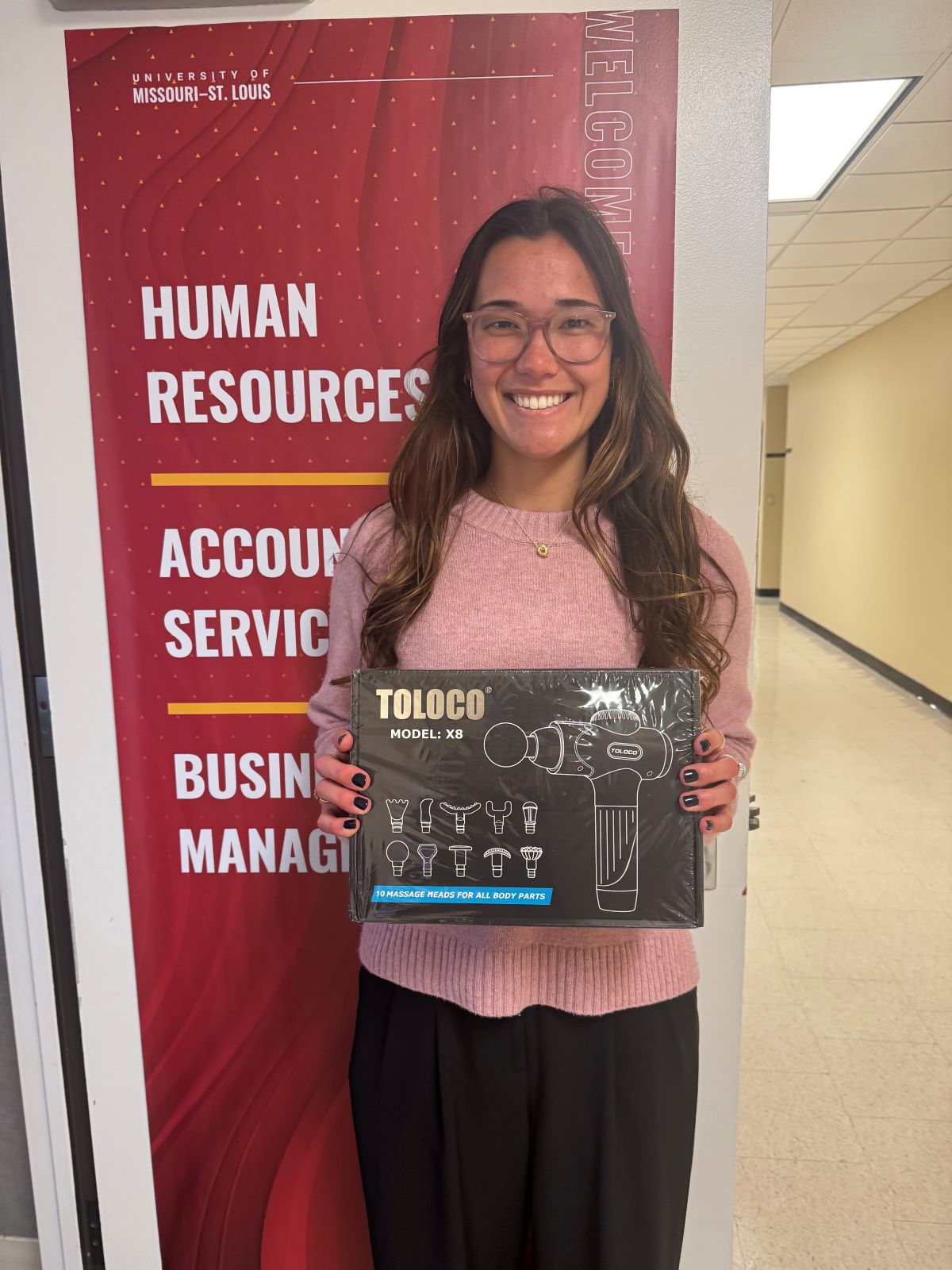 Photo of Walking Club winner holding massage gun prize